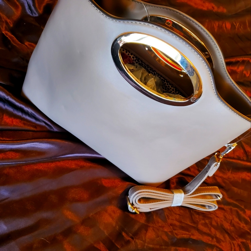 Light gray clutch purse with gold highlighted handle.